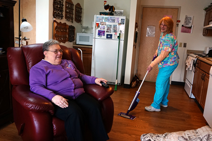 Brevillier Village volunteer vacuuming residents apartment in Barnabas Court.