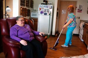 Brevillier Village volunteer vacuums Barnabas Court residents floor.